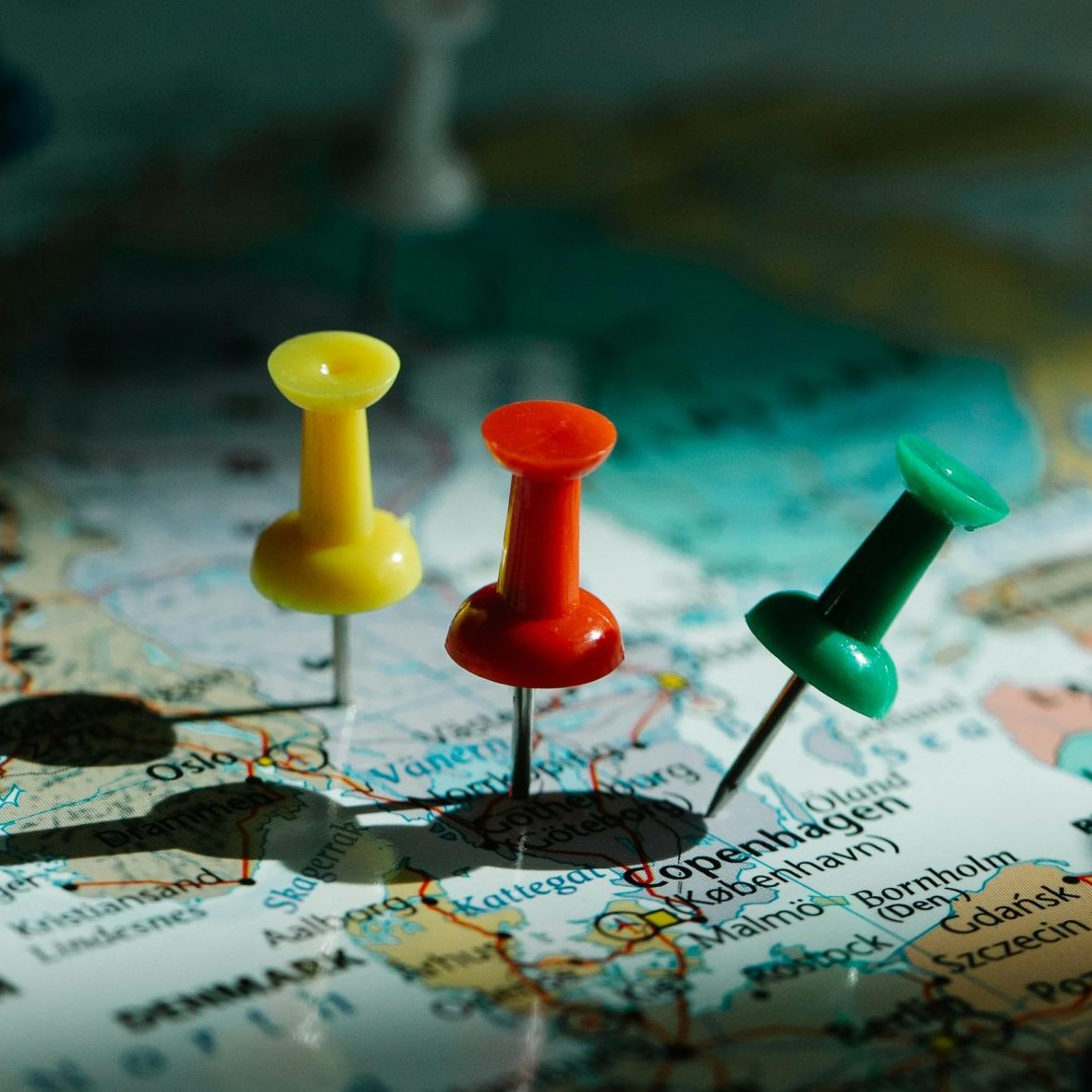 Close-up of colorful pins on a world map, highlighting travel planning and exploration.